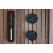 Tylö Brilliant Sauna-Set Eimer & Kelle Schwarz mit Thermometer und Hygrometer auf Holzwand