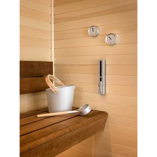 Tylö Brilliant Sauna-Set Eimer & Kelle Silber mit weißem Eimer und silberner Kelle auf Saunabank