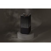 Tylö Crown Combi Saunaofen in Schwarz mit perforiertem Designmantel auf grauem Podest, modernes Saunaofendesign mit integrierter Steuerung