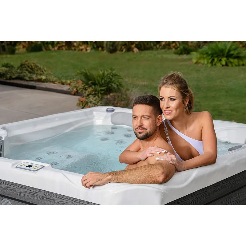 Wellis Budapest Life Whirlpool mit zwei Personen im Garten, Hydromassage-Düsen sichtbar