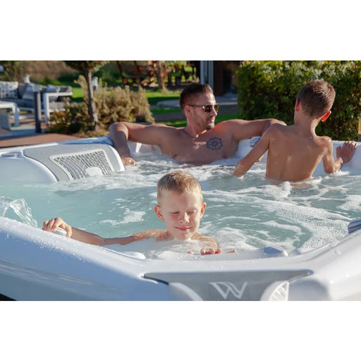 Wellis Elbrus Life Whirlpool mit Familie im Garten, sprudelndes Wasser und Massagejets