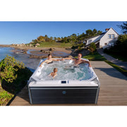 Wellis Elbrus Life Premium Whirlpool mit 7 Sitzplätzen und 61 Jets auf Holzterrasse mit Meerblick