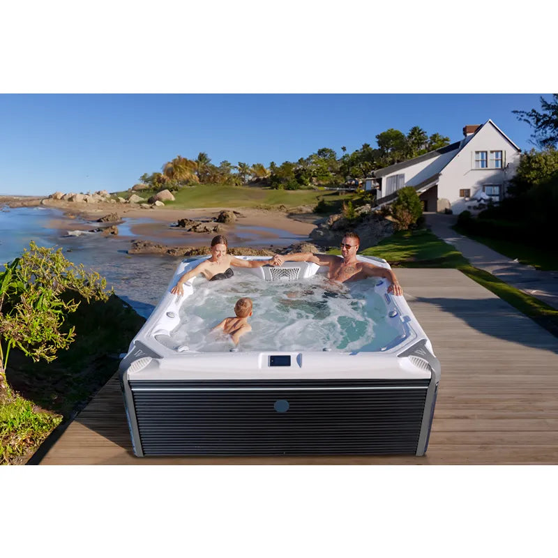 Wellis Elbrus Life Premium Whirlpool mit 7 Sitzplätzen und 61 Jets auf Holzterrasse mit Meerblick