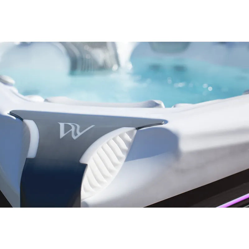 Wellis Elbrus Life Premium Whirlpool mit blauem Wasser und weißen Sitzen in Gartensetting