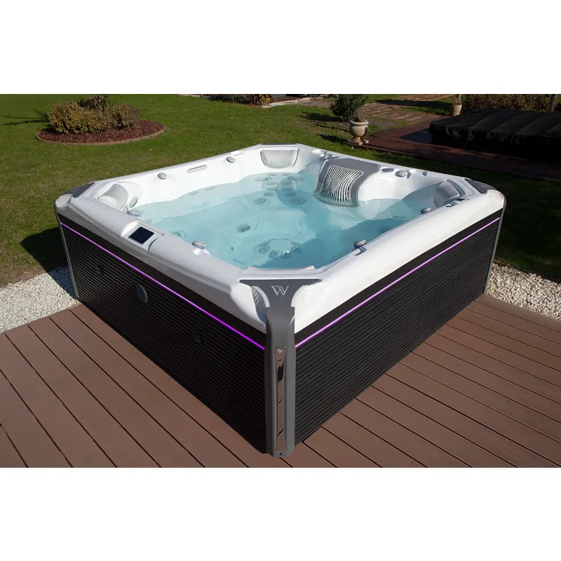 Wellis Elbrus Life Premium Whirlpool mit 7 Sitzen und 61 Jets auf Holzterrasse im Garten