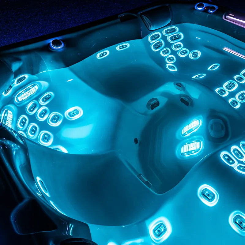 Wellis Everest Life Premium Whirlpool mit 68 beleuchteten Jets und 5 Sitzbereichen, Draufsicht bei Nacht mit blauem LED-Licht
