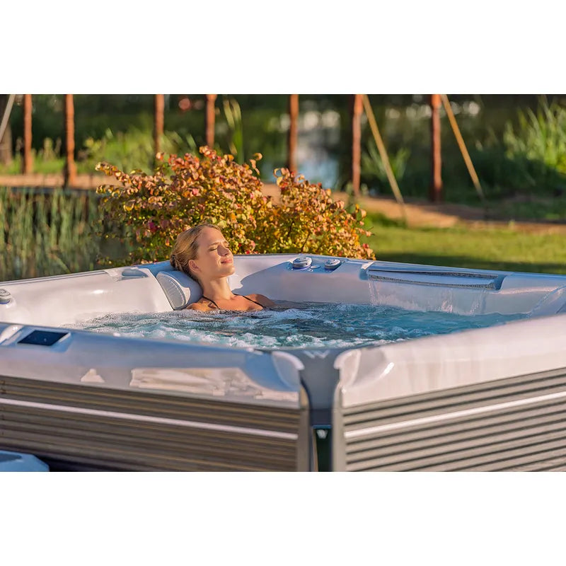 Wellis Everest Life Premium Whirlpool mit Frau in Garten, 68 Jets, entspannend im Freien