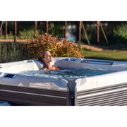 Frau entspannt in Wellis Everest Life Whirlpool im Garten mit sprudelnden Jets