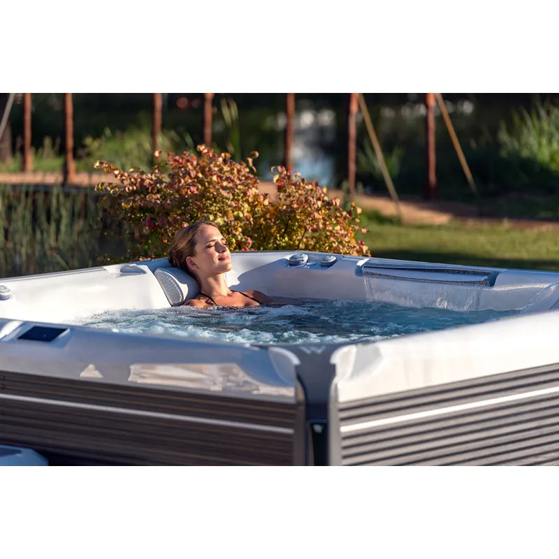Frau entspannt in Wellis Everest Life Whirlpool im Garten mit sprudelnden Jets