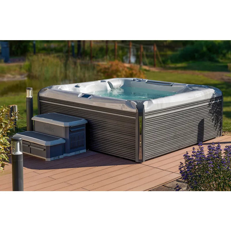 Wellis Everest Life Premium Whirlpool mit 5 Sitzen und 68 Jets auf Holzterrasse im Garten