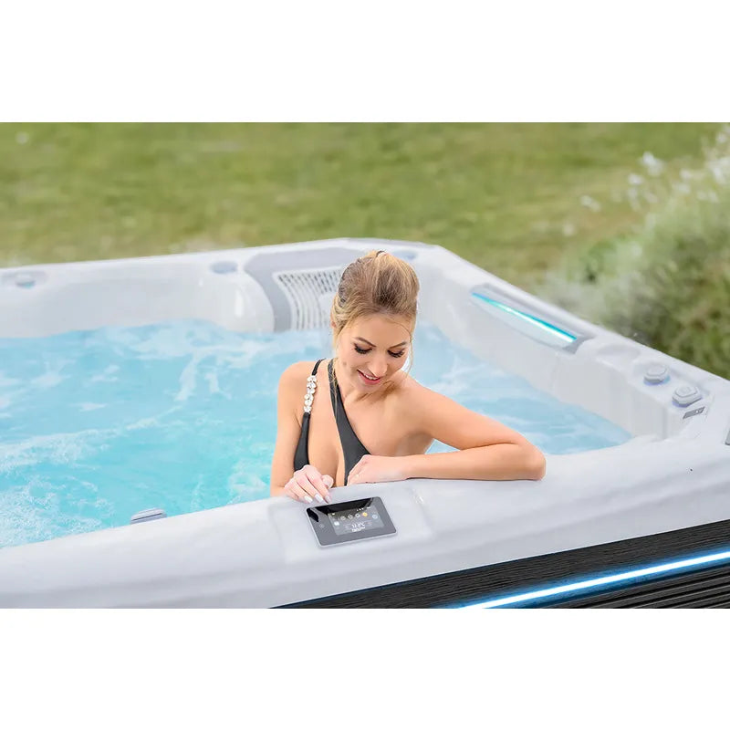 Wellis Kilimanjaro Life Premium Whirlpool mit Frau in Garten, Steuerungspanel sichtbar