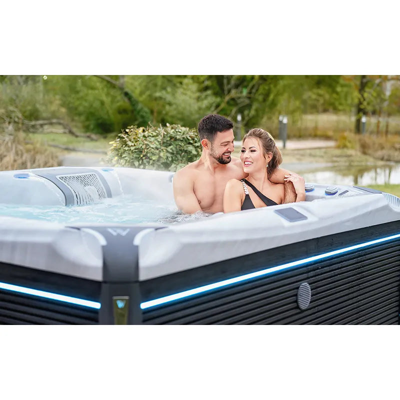 Wellis Kilimanjaro Life Premium Whirlpool mit 6 Sitzen und 59 Jets im Garten, Paar entspannt im warmen Wasser