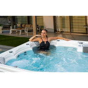 Wellis Kilimanjaro Life Premium Whirlpool mit Frau im warmen Wasser, weiße Außenschale, 59 Jets, Garten