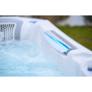 Wellis Kilimanjaro Life Premium Whirlpool mit sprudelndem Wasser und blauen LED-Jets in Gartenumgebung