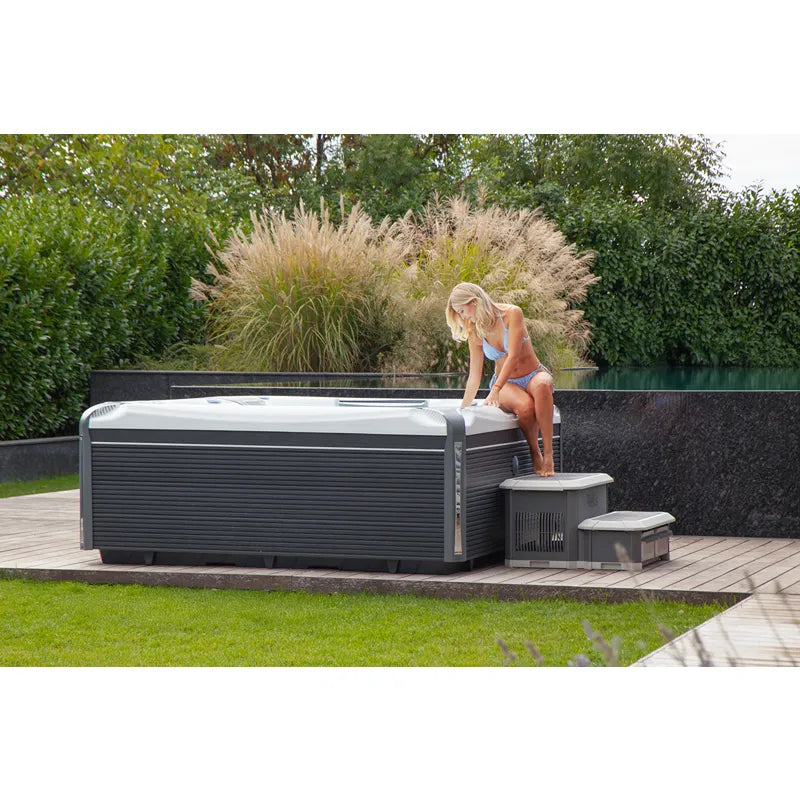 Wellis Kilimanjaro Life Premium Whirlpool mit 6 Sitzen im modernen Garten mit Terrasse und Hecke