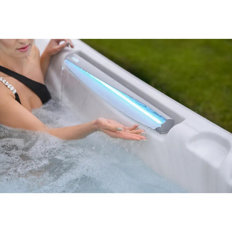 Frau genießt Wellis Kilimanjaro Life Whirlpool mit LED-Beleuchtung und sprudelndem Wasser im Garten
