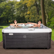 Wellis Lima Life Premium-Whirlpool mit 7 Sitzplätzen im Garten, zwei Personen entspannen im warmen Wasser