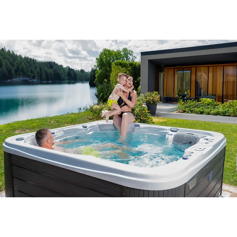 Wellis Lugano Life Premium-Whirlpool mit Familie im Garten am See, Entspannung mit Blick auf Wasser und Natur