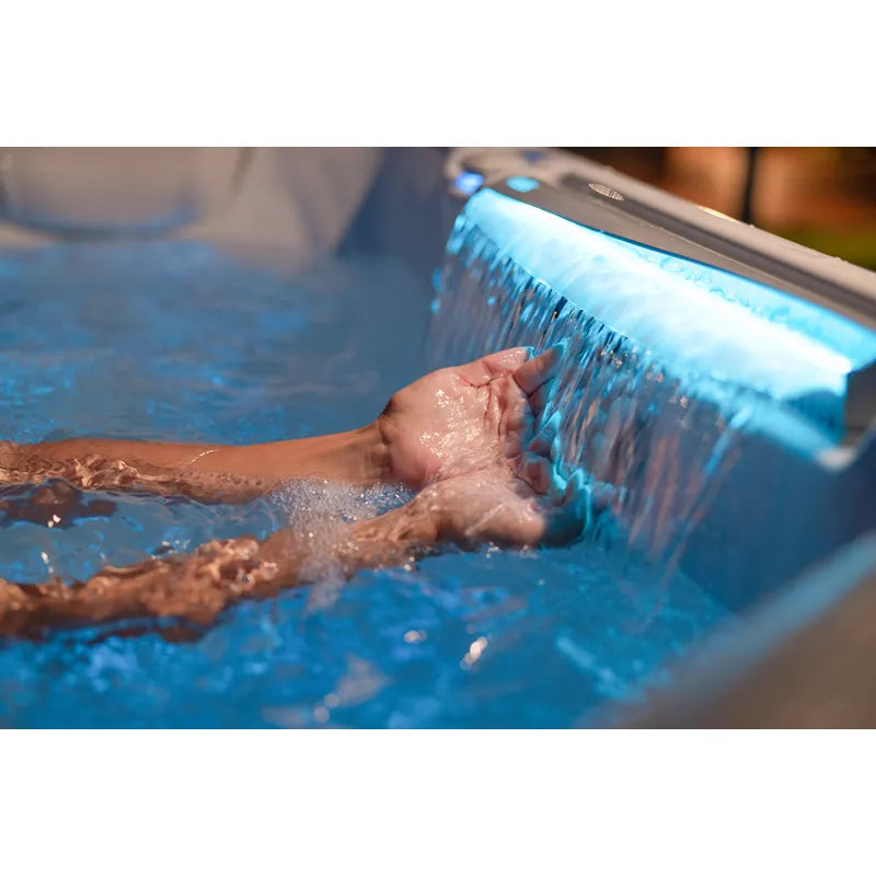 Wellis Makalu Life Whirlpool mit aktivem Wasserstrahl und Person im blauen Wasser