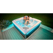 Wellis Makalu Life Premium Whirlpool mit 5 Sitzen und 51 Jets im Garten, zwei Personen entspannen im warmen Wasser