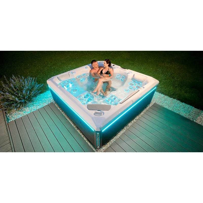 Wellis Makalu Life Premium Whirlpool mit 5 Sitzen und 51 Jets im Garten, zwei Personen entspannen im warmen Wasser