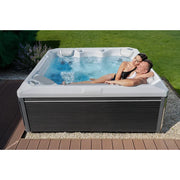 Wellis Makalu Life Premium Whirlpool mit 5 Sitzen und 51 Jets, zwei Personen entspannen im sprudelnden Wasser auf der Terrasse