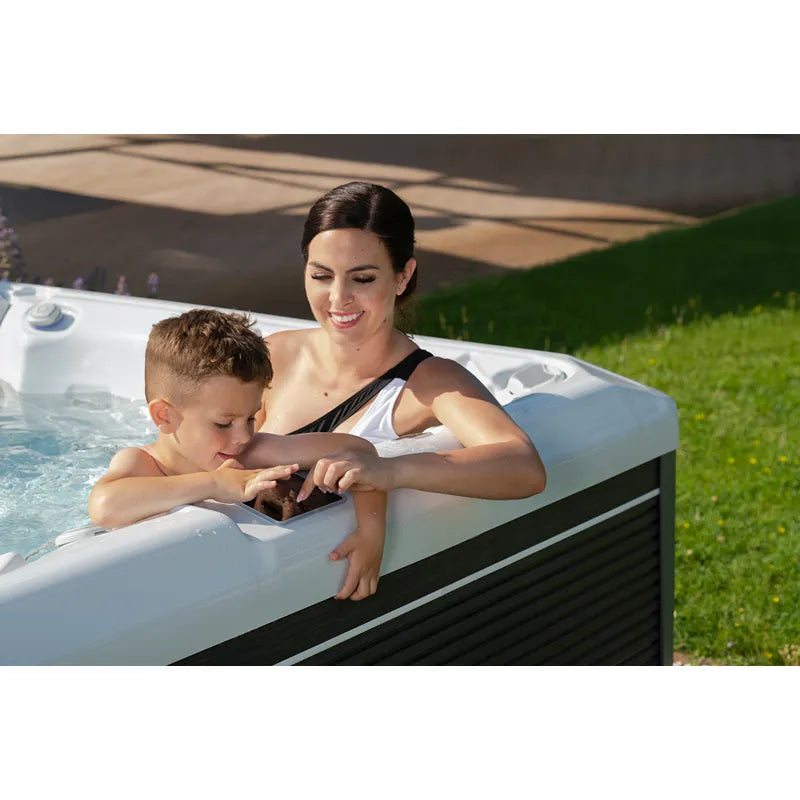 Mutter und Kind genießen Makalu Life Whirlpool von Wellis im Garten mit sprudelndem Wasser und Jets