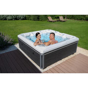 Wellis Makalu Life Premium Whirlpool mit 5 Sitzen und 51 Jets im Garten, zwei Personen entspannen im sprudelnden Wasser