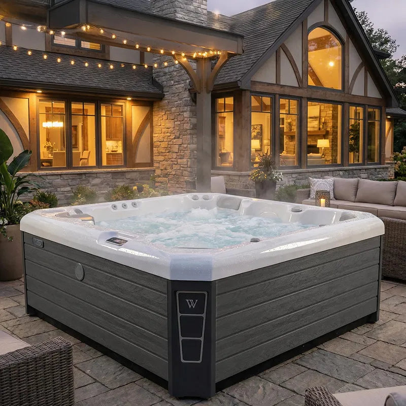 Wellis Malaga Life Premium-Whirlpool mit sprudelndem Wasser im Garten vor moderner Architektur