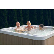 Wellis Malaga Life Premium-Whirlpool mit Familie beim Entspannen im Garten vor Hecke