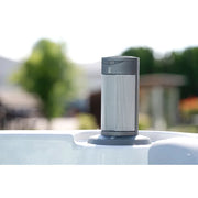 Wellis Olympus Life Premium Whirlpool Steuereinheit am Rand eines Whirlpools mit Gartensicht