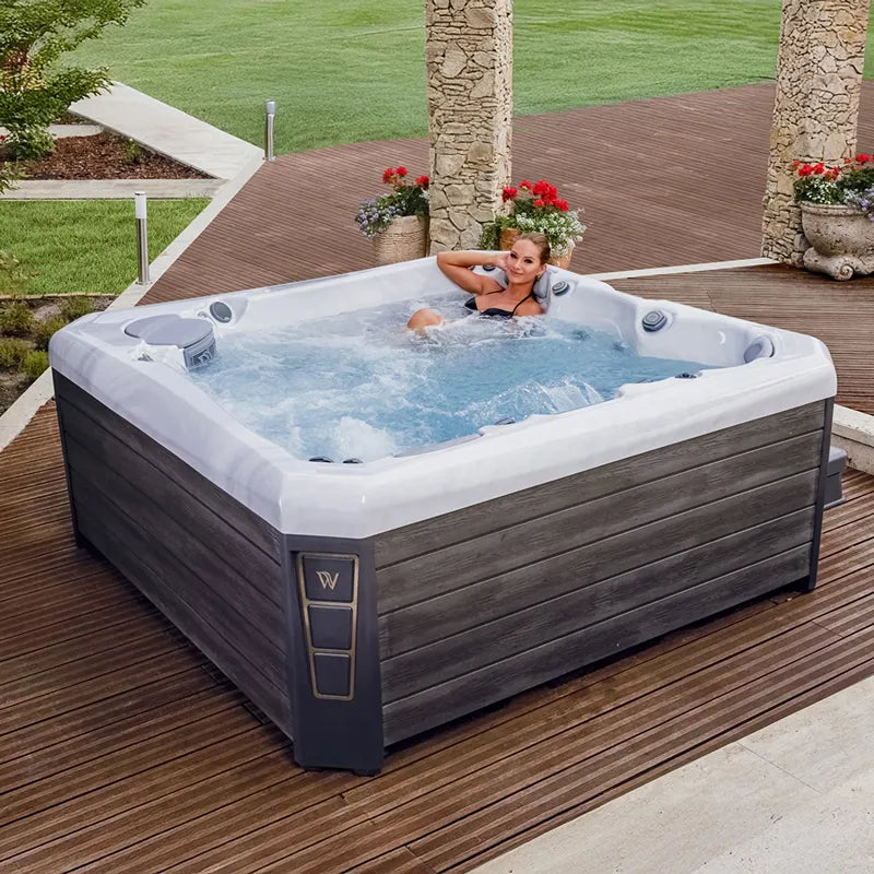 Wellis Palermo Life Premium-Whirlpool mit Frau im sprudelnden Wasser auf Terrasse