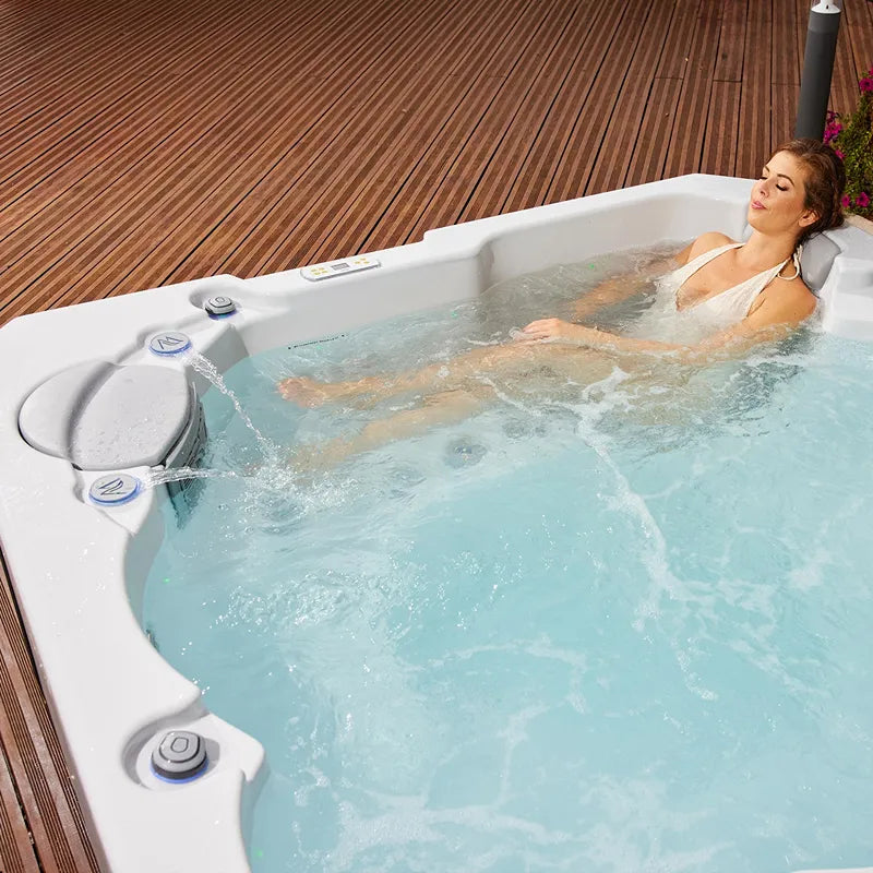 Wellis Prague Life Whirlpool mit Frau in türkisem Wasser auf Holzterrasse
