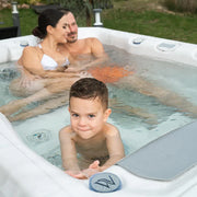 Wellis Teide Life Whirlpool mit Familie im Garten, Eltern und Kind genießen warmes Wasser