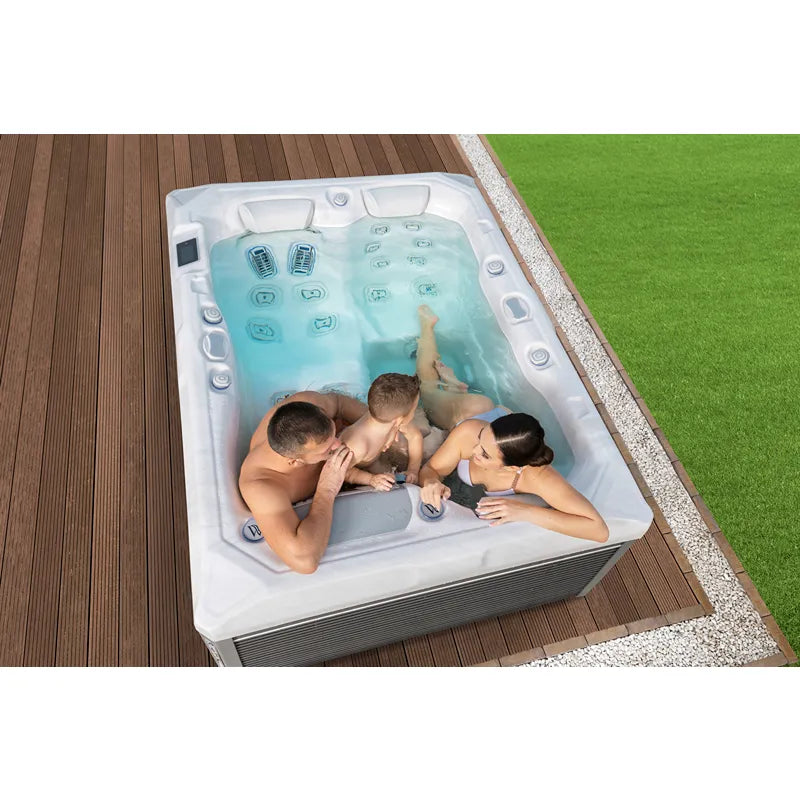Wellis Teide Life Premium Whirlpool mit 3 Sitzplätzen und 32 Jets, Familie entspannt im türkisblauem Wasser auf Holzterrasse