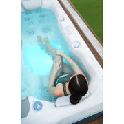 Wellis Teide Life Premium Whirlpool mit Frau in türkisblauem Wasser, weiße Einfassung und Düsen sichtbar