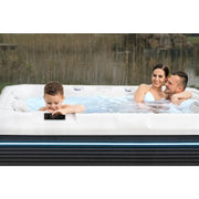 Familie genießt Wellis Teide Life Whirlpool im Garten mit sprudelndem Wasser und Massagedüsen