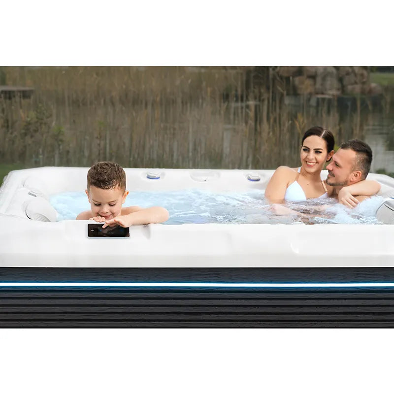 Familie genießt Wellis Teide Life Whirlpool im Garten mit sprudelndem Wasser und Massagedüsen