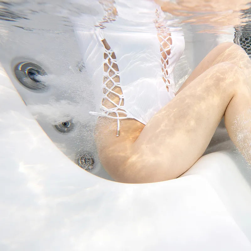 Wellis Vienna Life Whirlpool mit Person beim entspannten Baden in sprudelndem Wasser