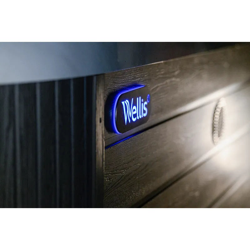 Wellis Vienna Life Whirlpool mit blau beleuchteter Hersteller-Logo und Holzverkleidung