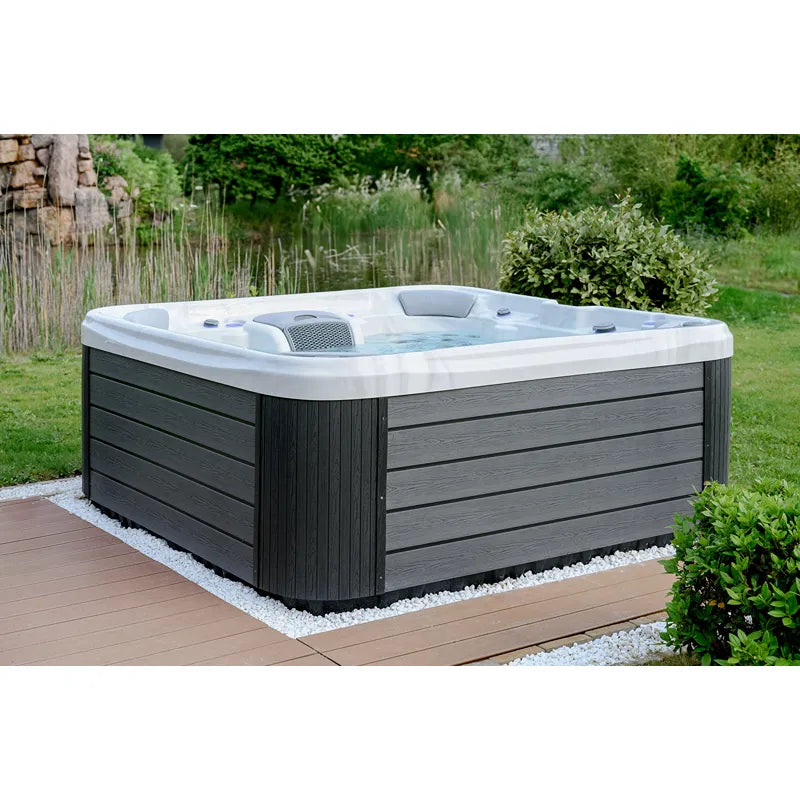 Wellis Vienna Life Premium-Whirlpool mit weißem Becken und dunkelgrauem Holzrahmen im Garten