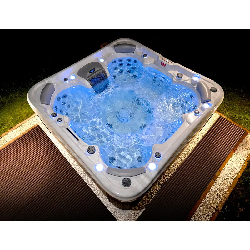 Wellis Vienna Life Premium-Whirlpool mit sprudelndem Wasser, LED-Beleuchtung und Massagedüsen bei Nacht im Garten
