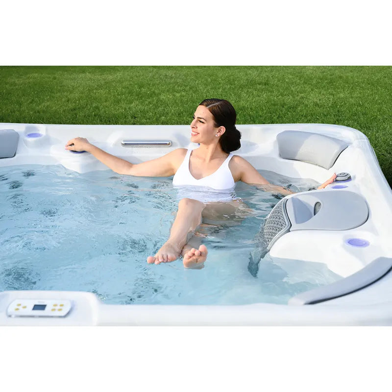 Frau entspannt im Wellis Vienna Life Premium-Whirlpool mit sprudelndem Wasser im Garten