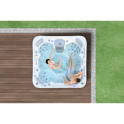 Wellis Vienna Life Premium-Whirlpool mit zwei Personen im türkisfarbenen Wasser, Draufsicht auf die 7-Personen-Wellness-Badewanne im Garten