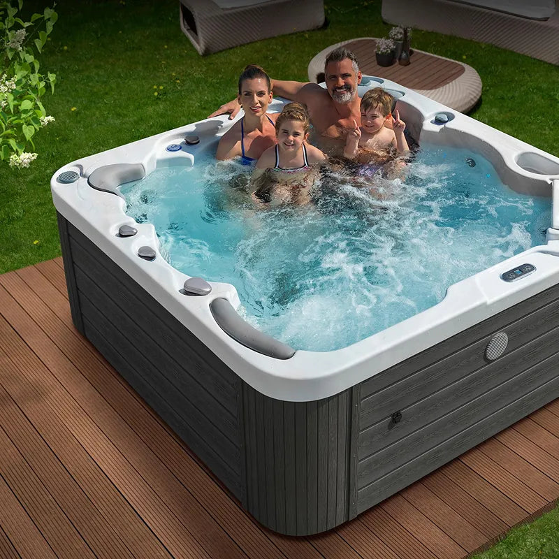 Wellis Jupiter – Classic Line Whirlpool 6 Personen mit Familie im Garten auf Holzterrasse