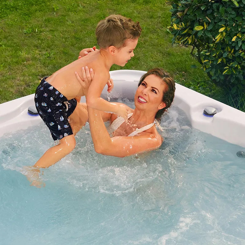 Wellis Jupiter – Classic Line Whirlpool 6 Personen mit Mutter und Kind beim Entspannen im warmen Wasser im Garten