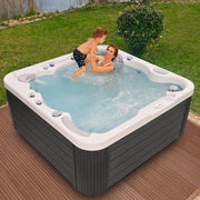 Wellis Jupiter – Classic Line Whirlpool 6 Personen mit Mutter und Kind im sprudelnden Wasser auf Holzterrasse
