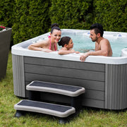 Wellis Jupiter – Classic Line Whirlpool 6 Personen mit Familie im Garten, weißes Becken mit grauem Holzrahmen