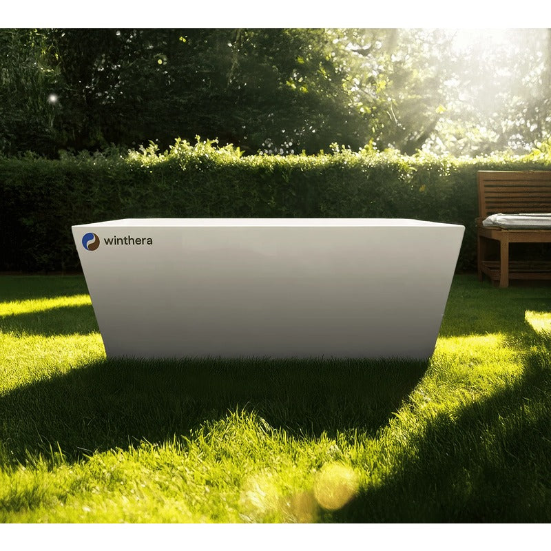 Winthera Arctic Acryl Eisbad in Weiß, freistehend im sonnigen Garten auf grüner Wiese mit Bäumen und Sichtschutz im Hintergrund