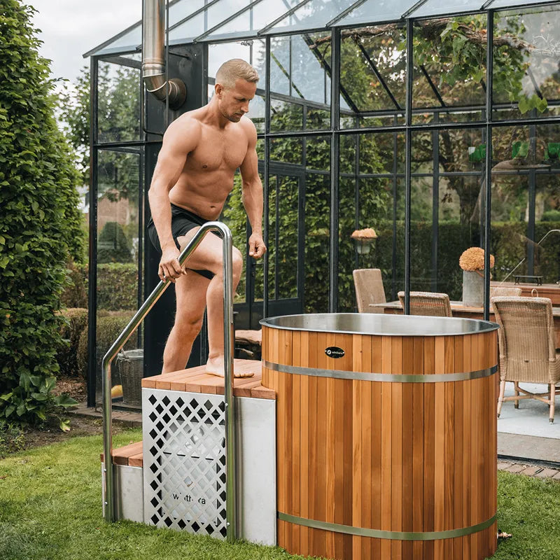 Winthera Arctic Barrel Eisbad mit Mann beim Einstieg, Holzfass Meisterstück im Garten